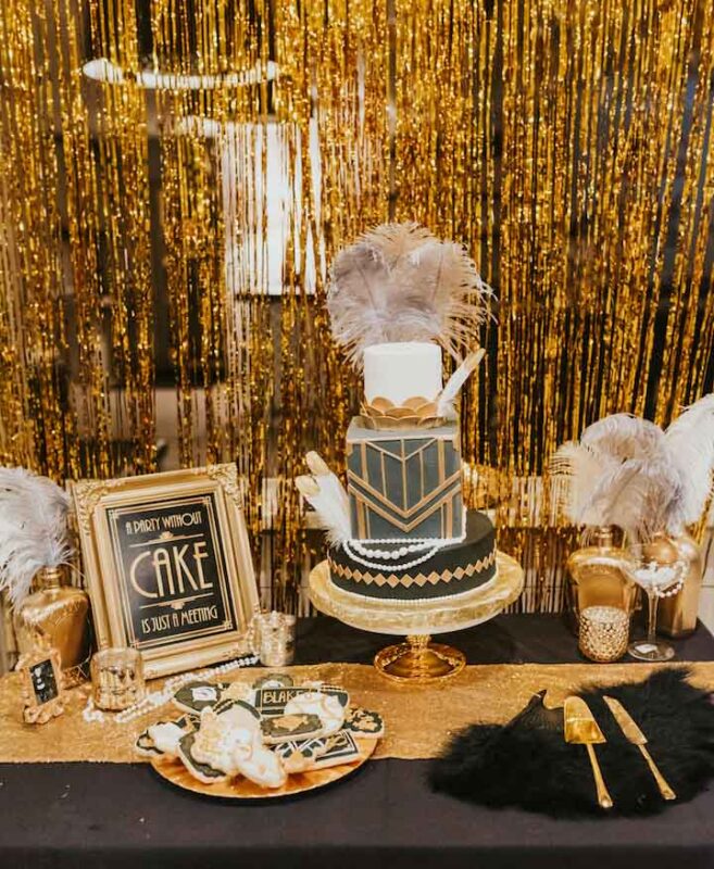 great gatsby themed table setting with a large black and gold geometric cake