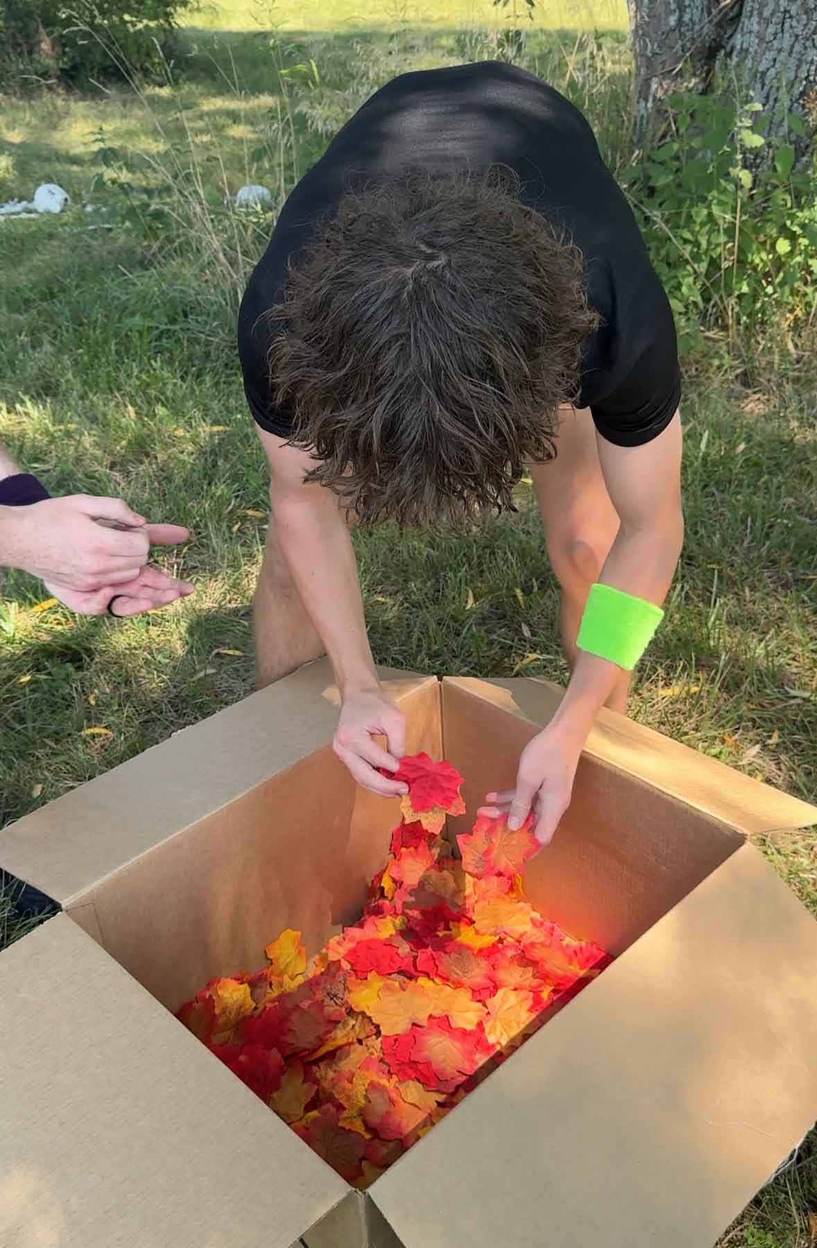 teenager searching through a bucket of leaves