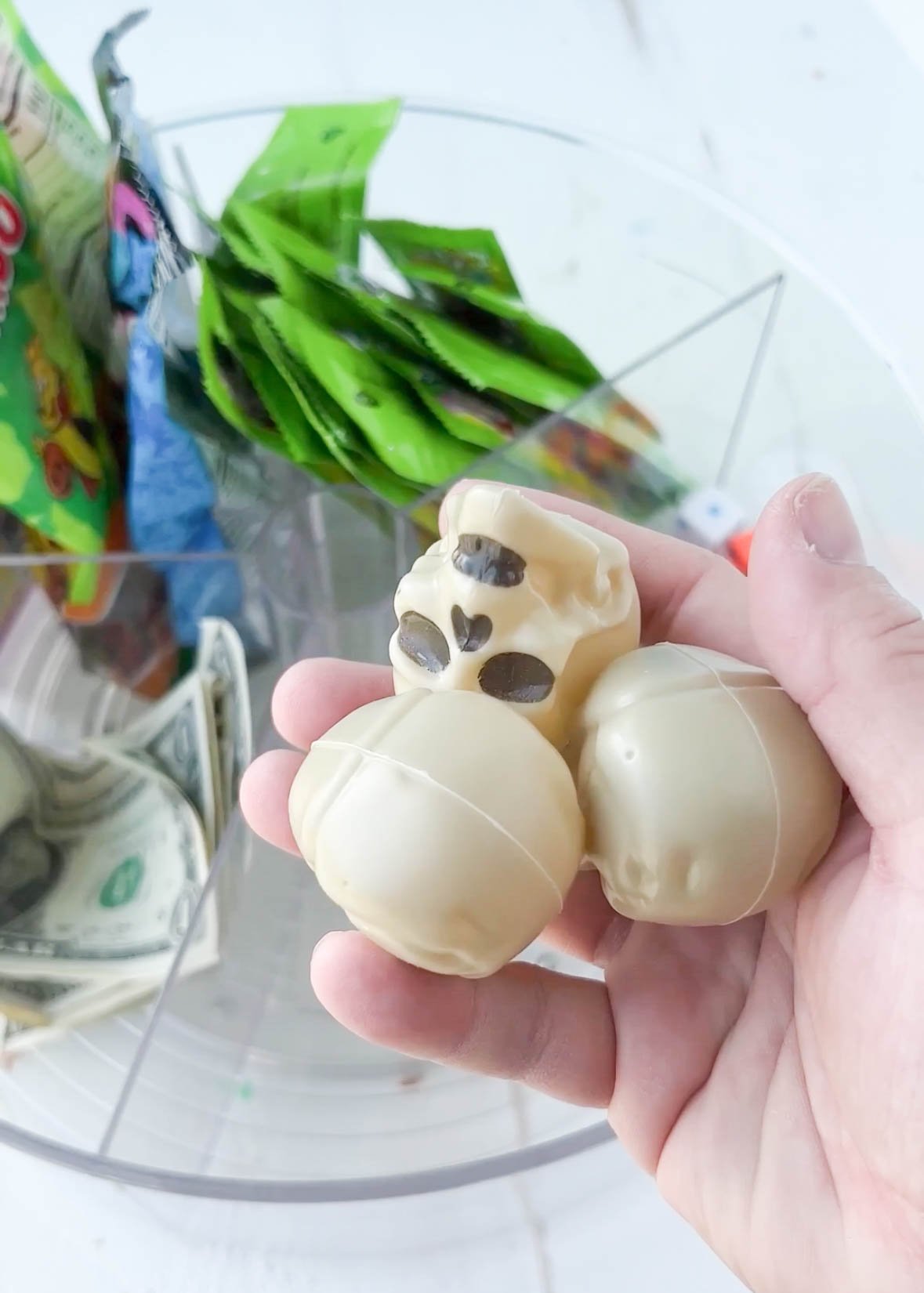 hand holding some plastic skulls above a lazy susan