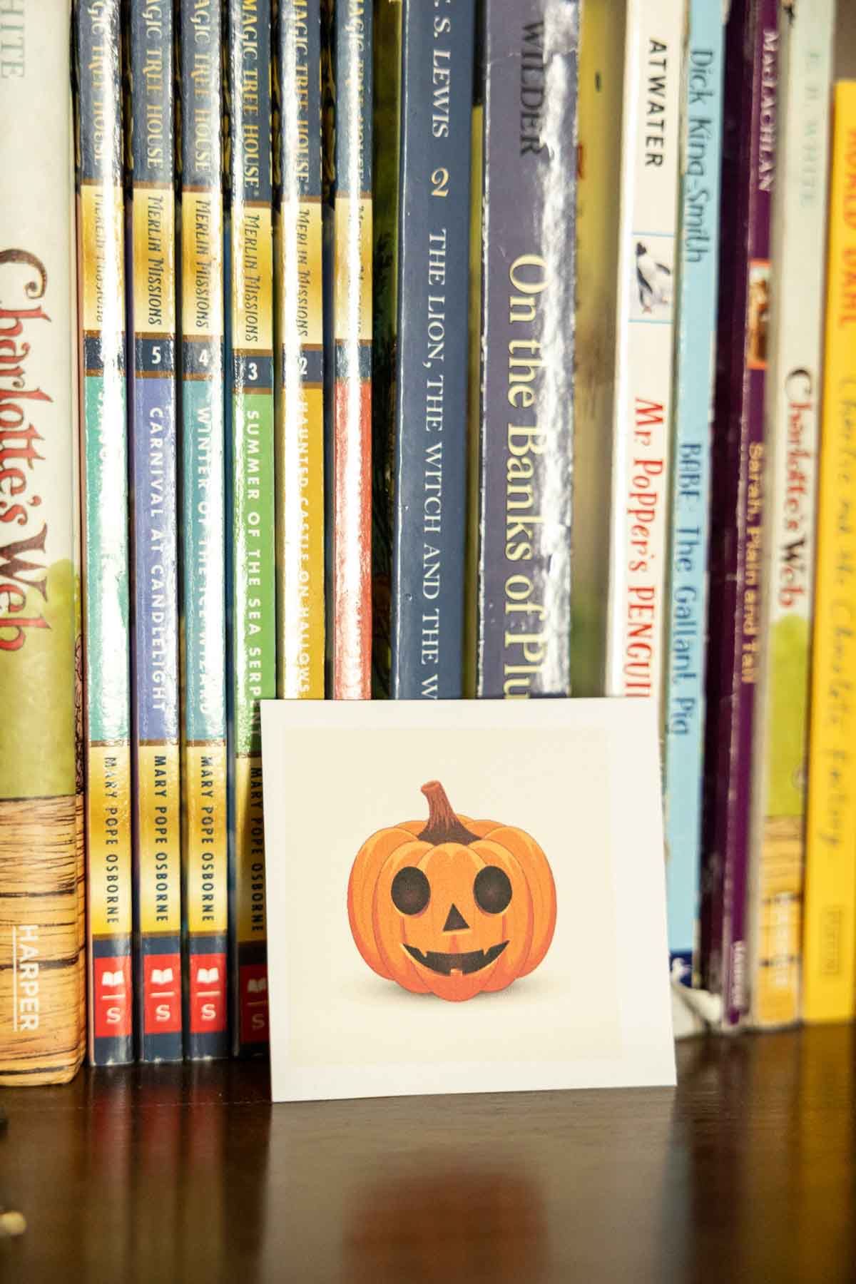 pumpkin card in front of a bunch of books