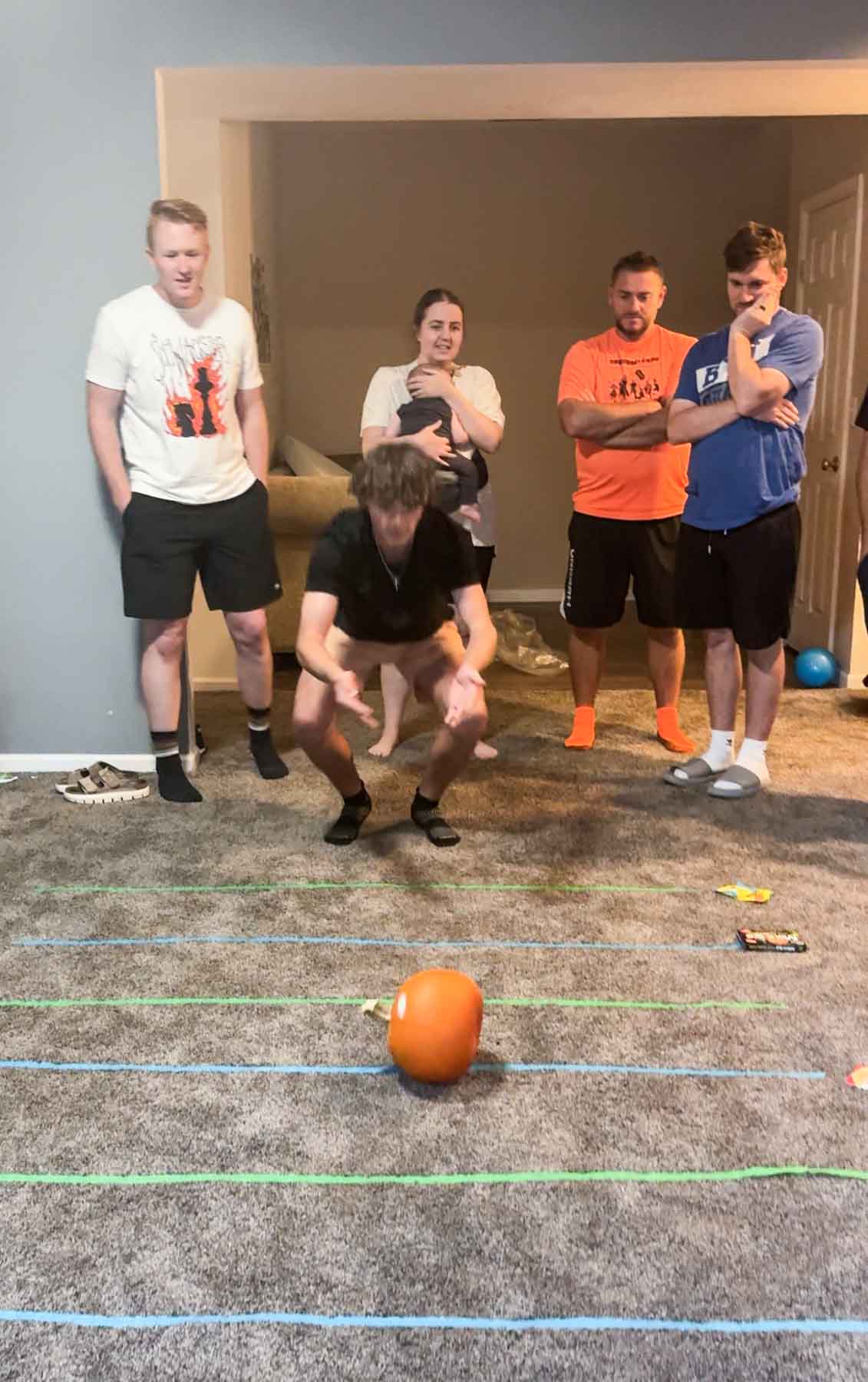 pumpkin rolling along lines of tape on a carpet