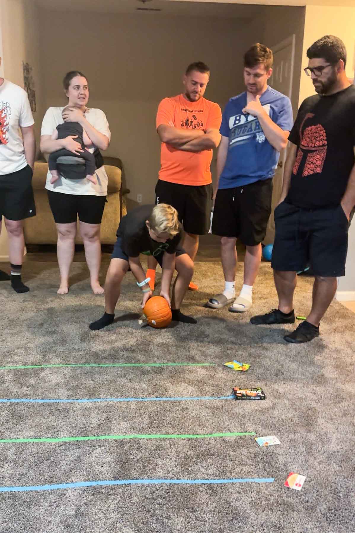 kid rolling a pumpkin on carpet