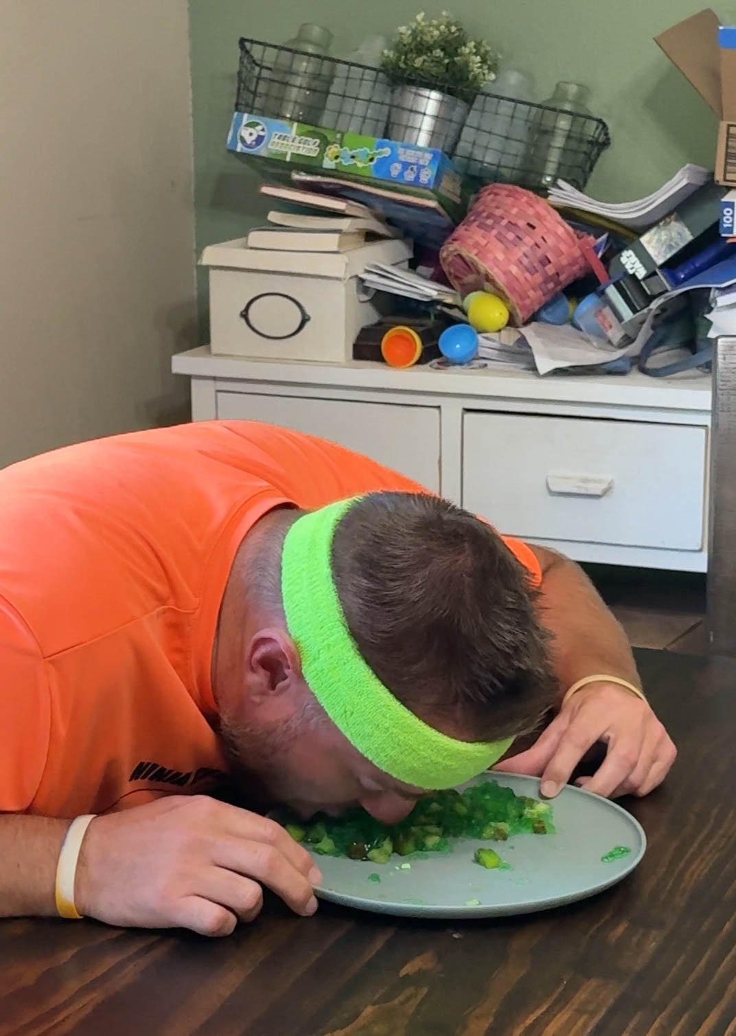 man eating green jello off the plate