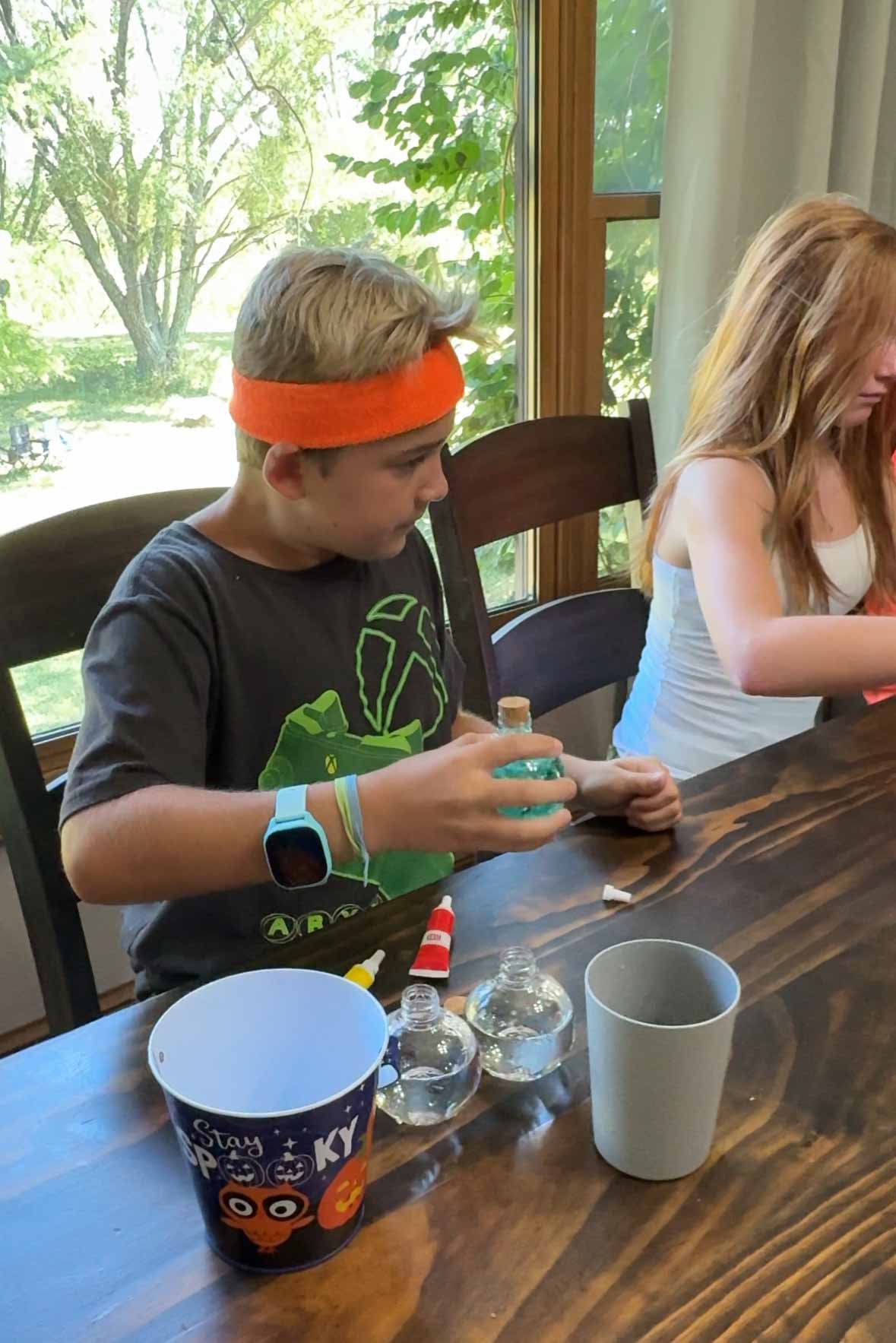 boy shaking up a bottle of blue colored water