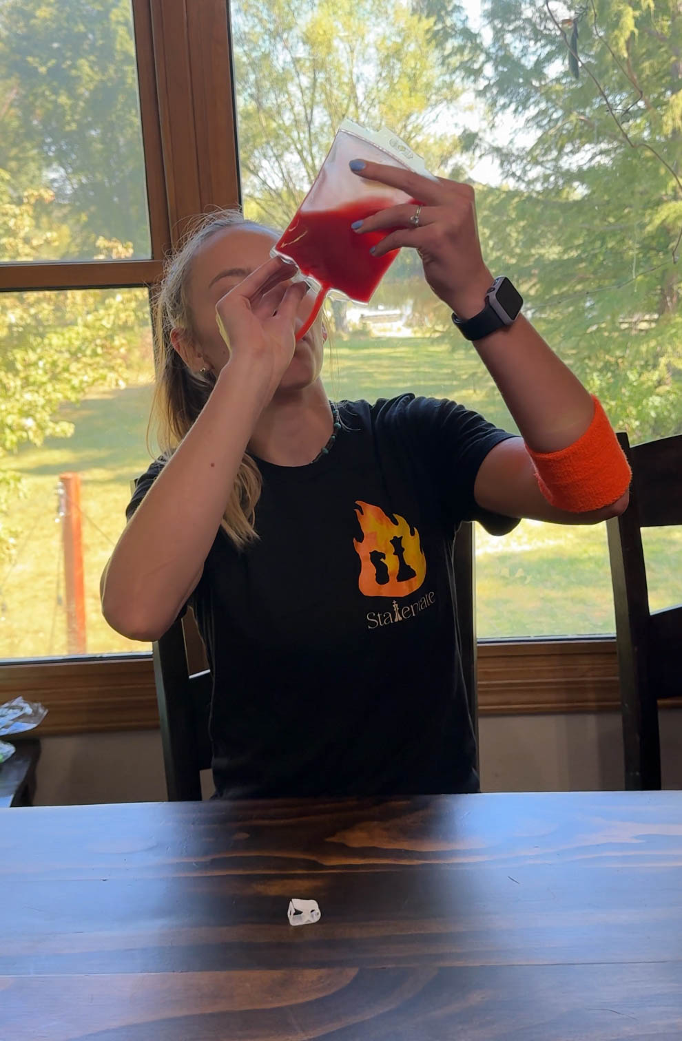 woman drinking tomato juice out of a blood bag