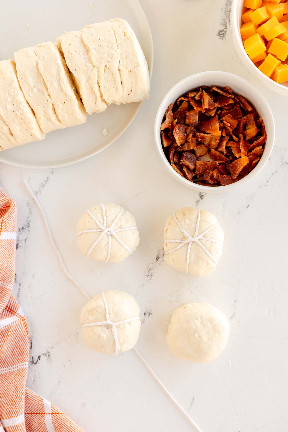 unbaked pumpkin shaped rolls tied with baking twine