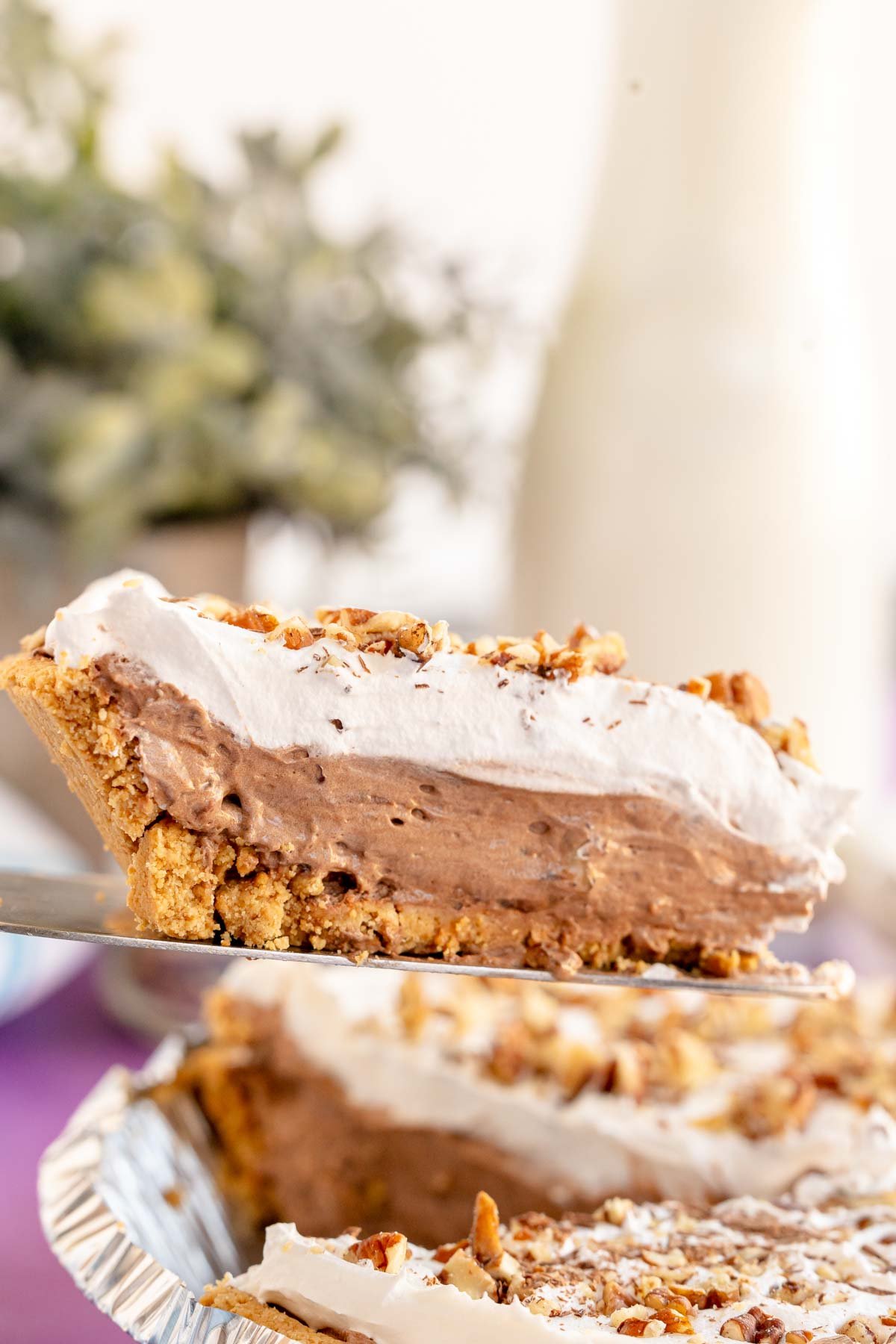 slice of chocolate pudding pie above a pie tin full of chocolate pudding pie