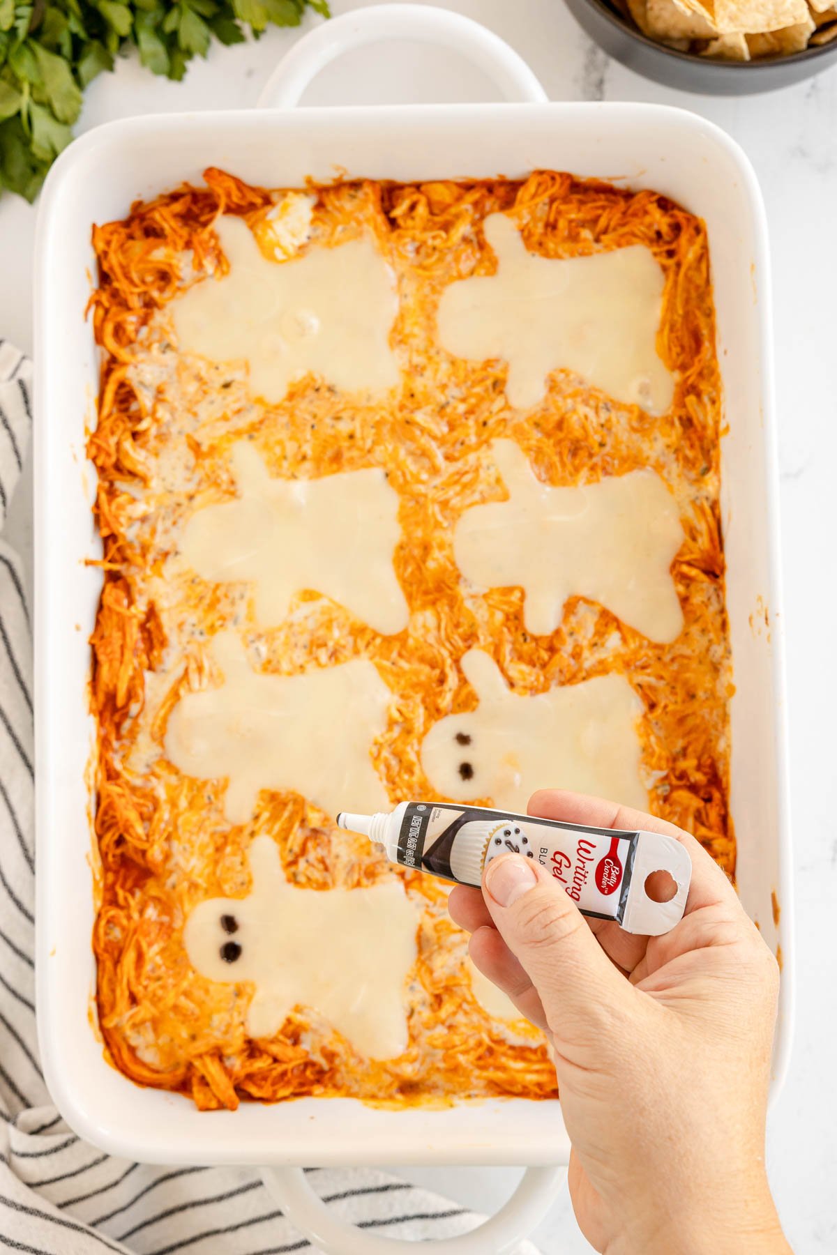 adding edible eyes to ghosts on Halloween buffalo chicken dip