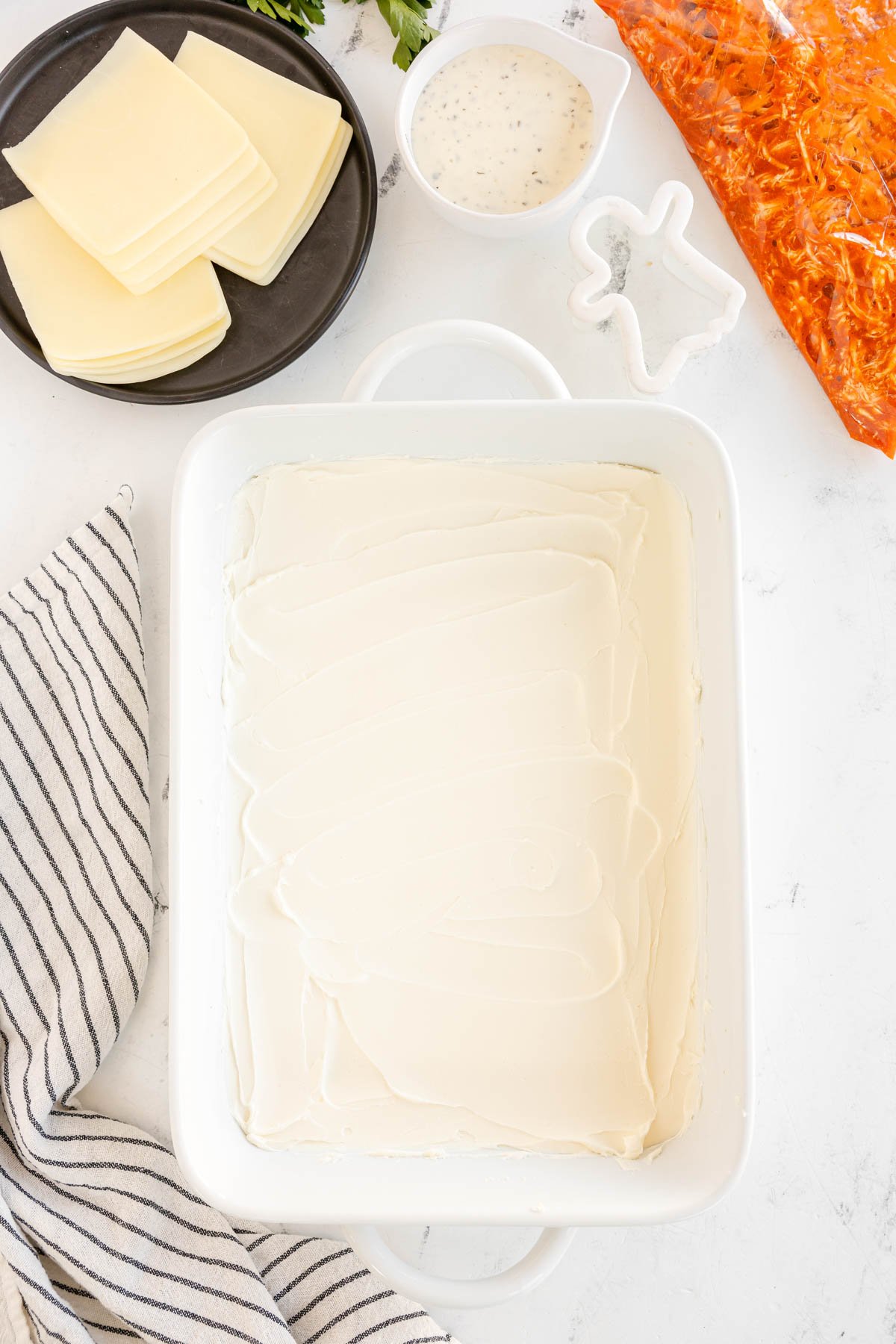 cream cheese spread on the bottom of a 9x13 baking dish