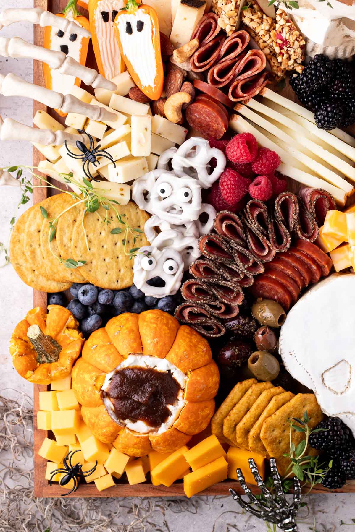 Halloween charcuterie board with ghost pretzels, a filled pumpkin, an ghost peppers