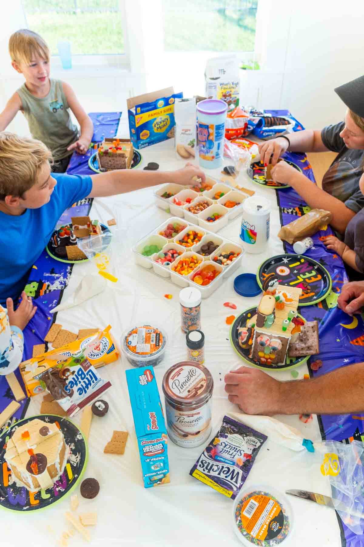 people making Halloween gingerbread houses