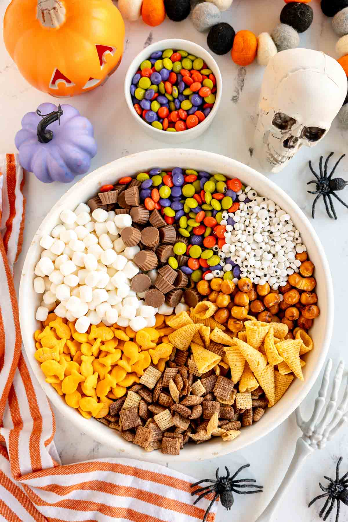 unmixed snack mix for Halloween in a white bowl