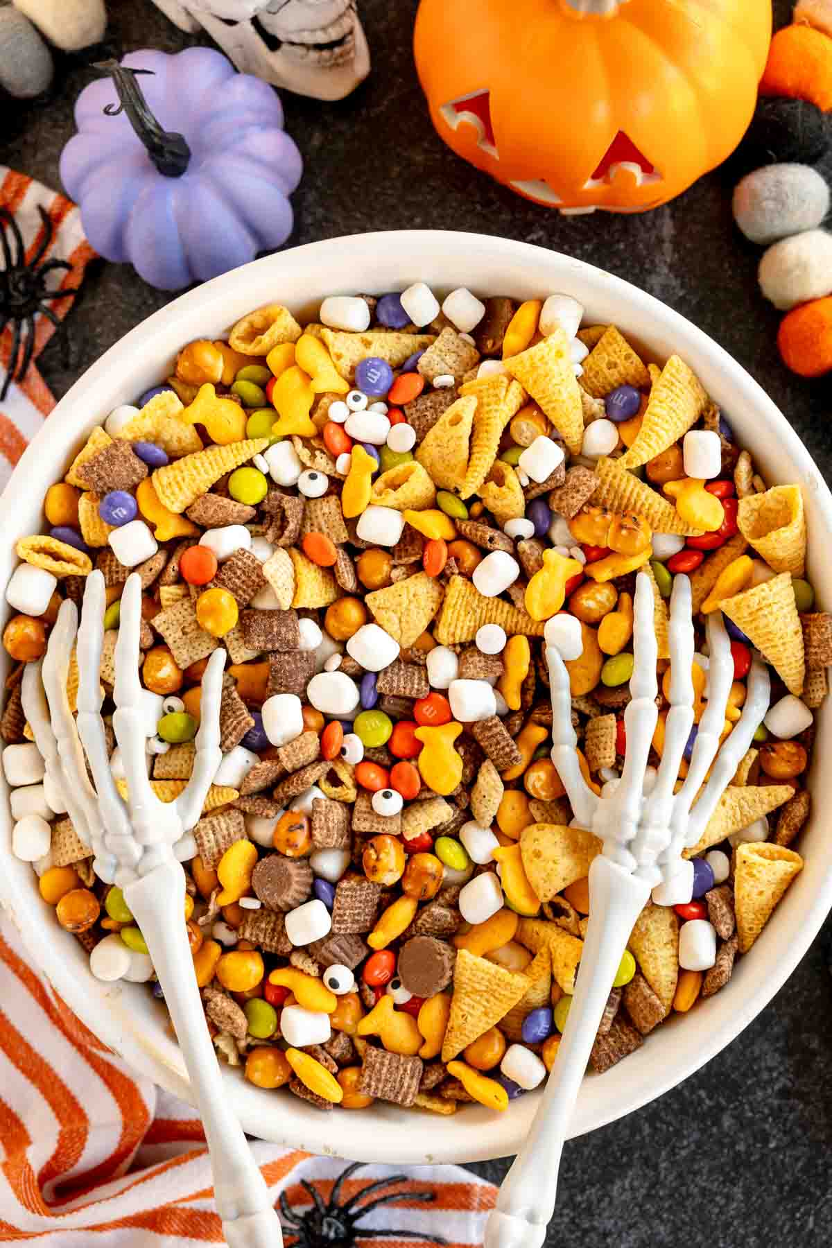 large bowl of snack mix for Halloween with skeleton hands