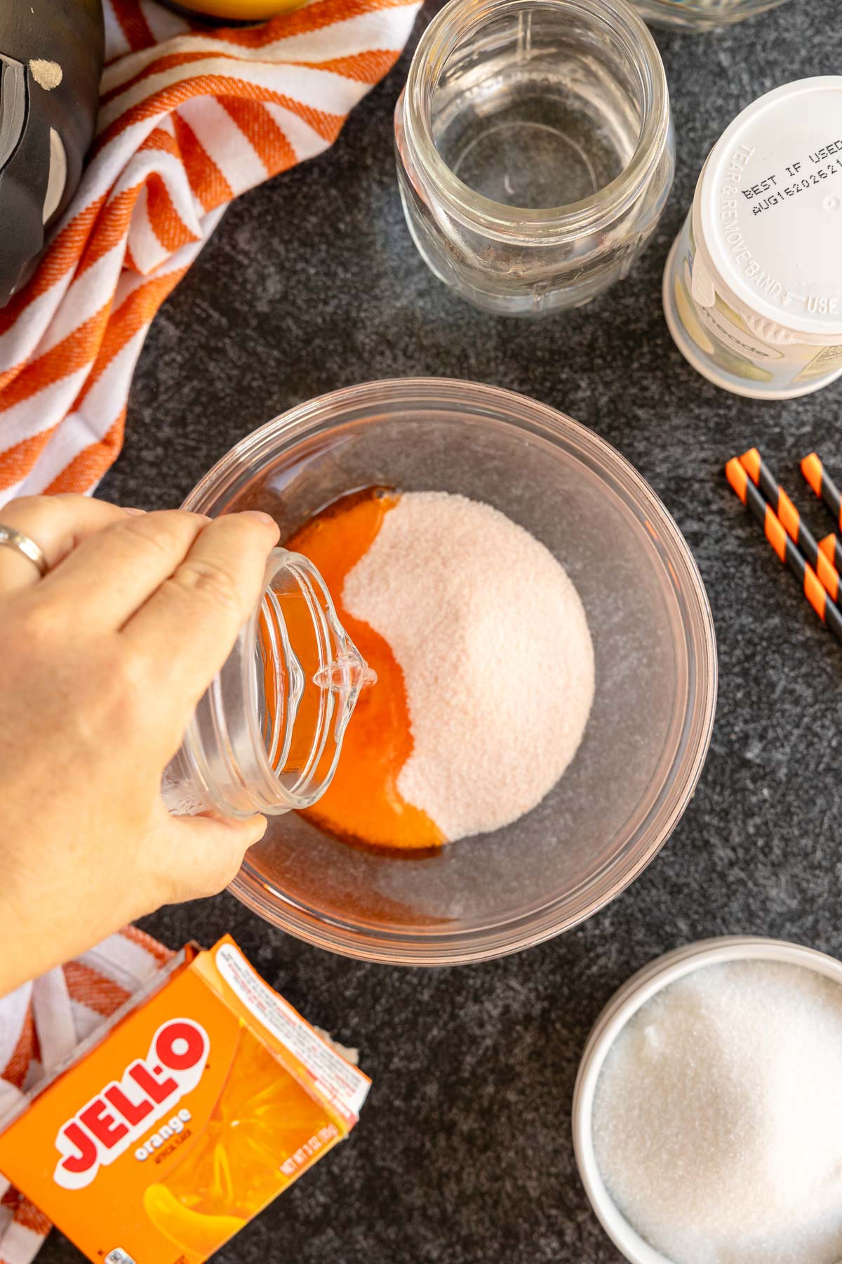 making orange jello in a glass bowl