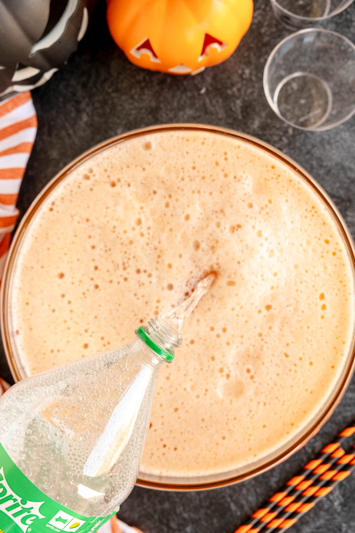 pouring Sprite into an orange pumpkin punch