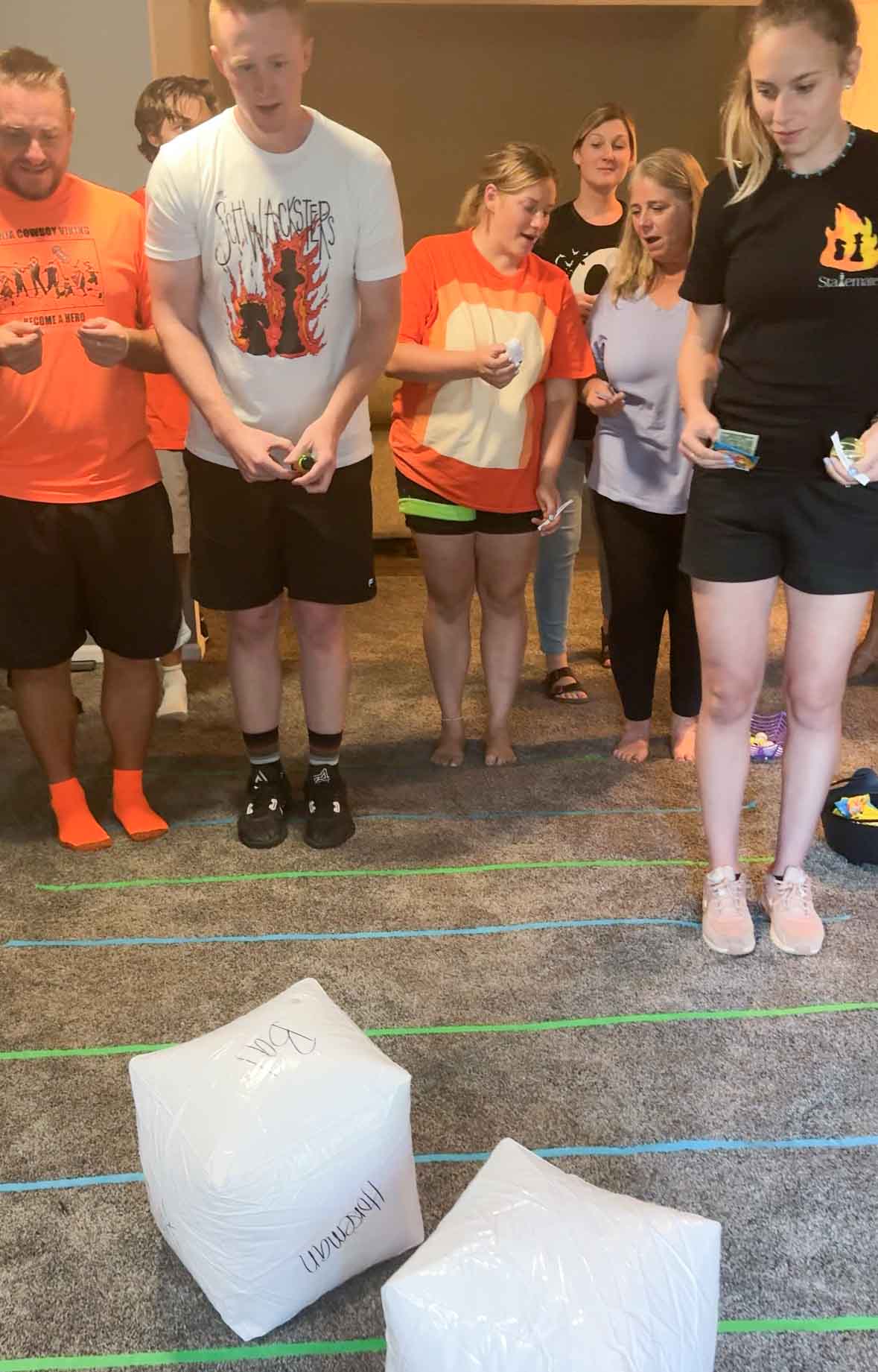 people standing around looking at inflatable dice playing a Halloween game