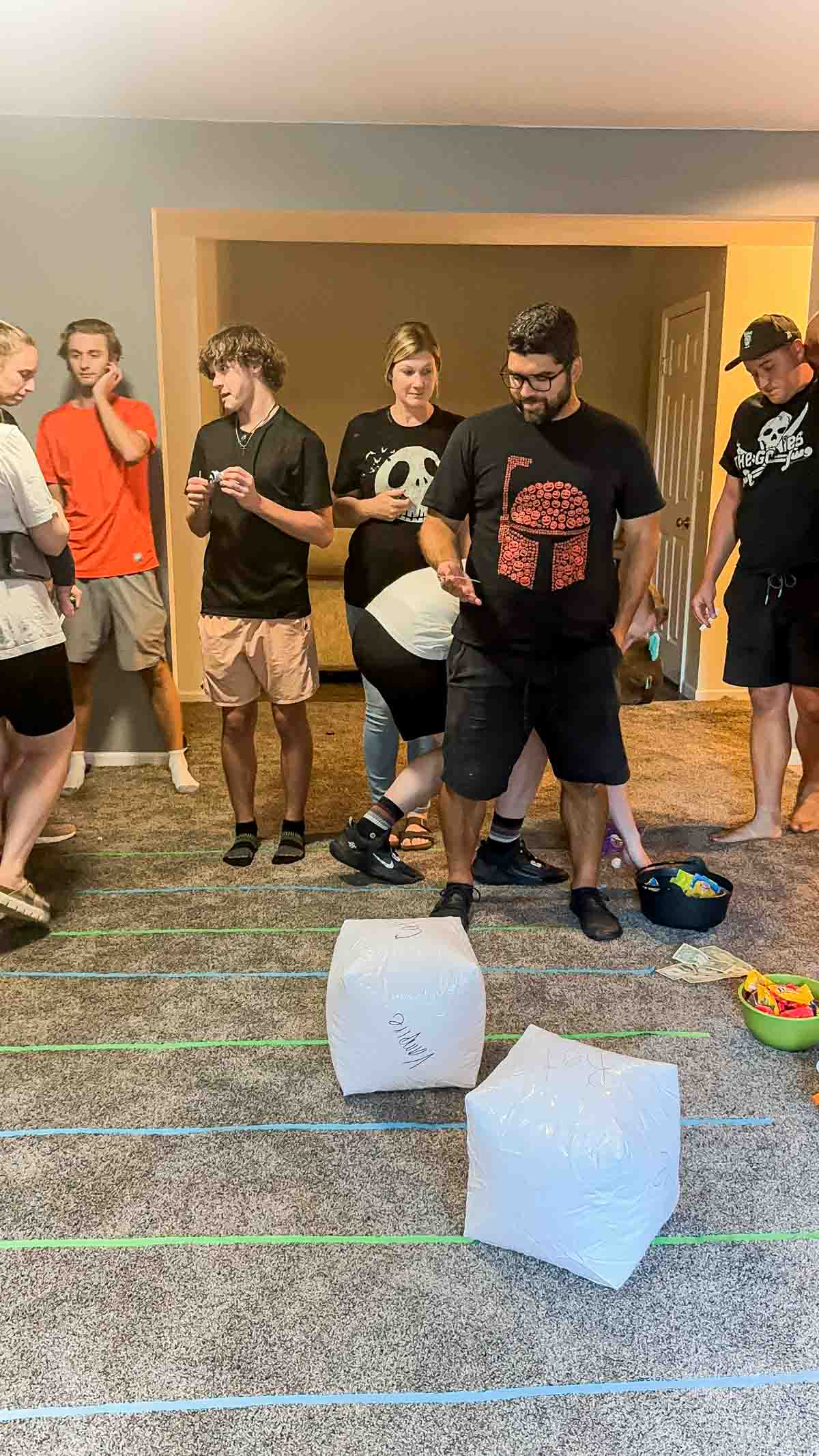 two inflatable dice on a game board made out of tape and prizes