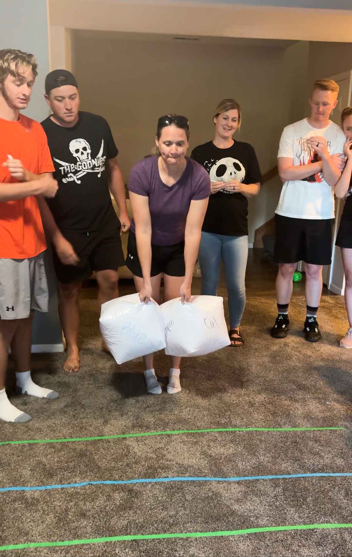 woman holding two inflatable dice standing on a game board