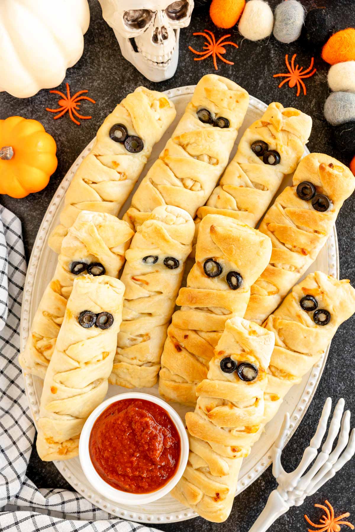 mummy pizza loaves on a silver tray with pizza sauce