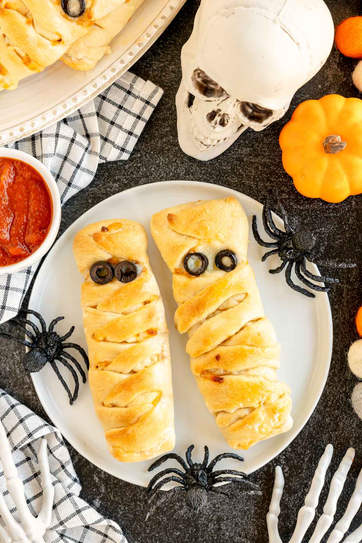 two mummy pizza loaves on a white plate