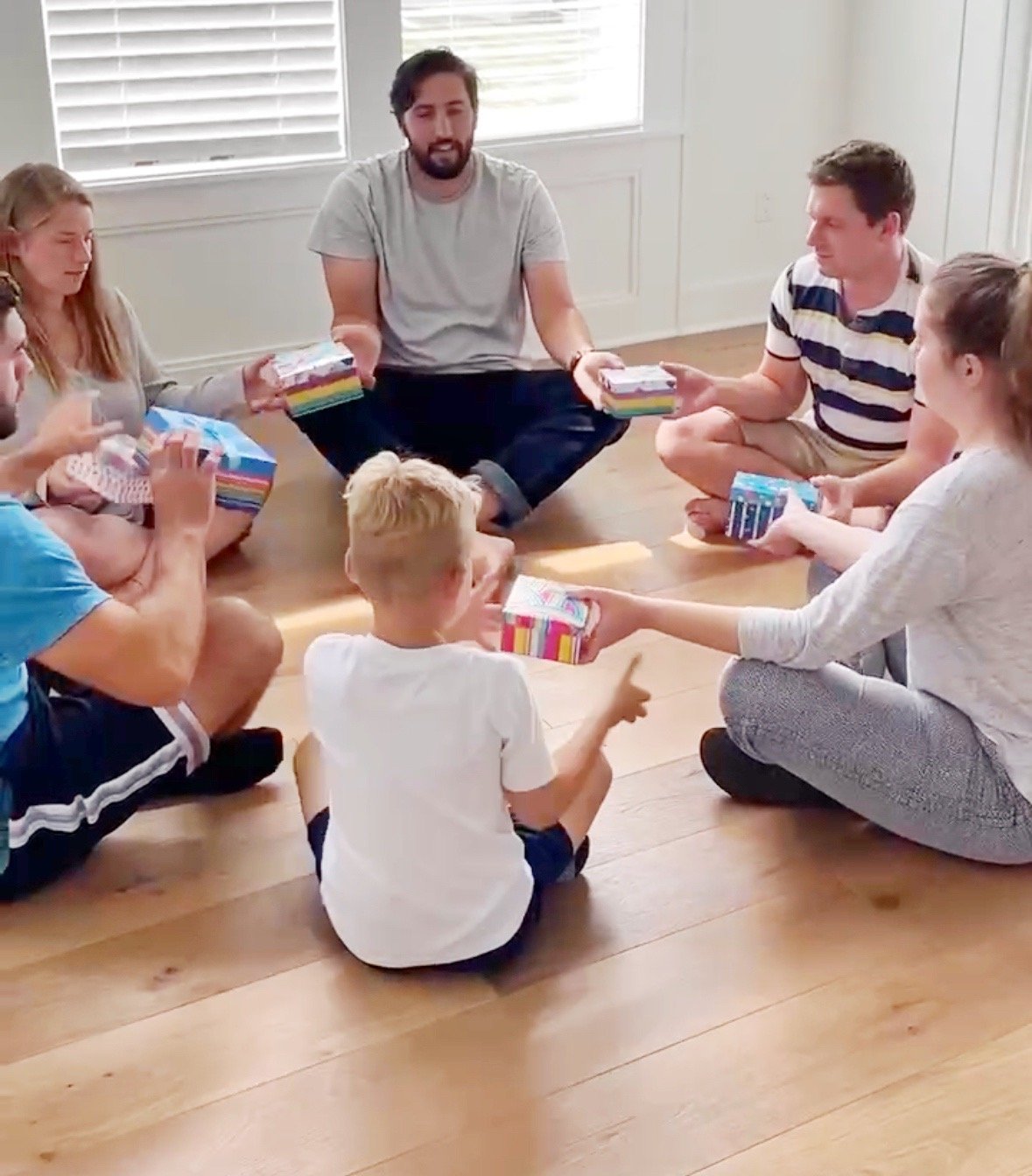 people sitting in a circle passing gifts around