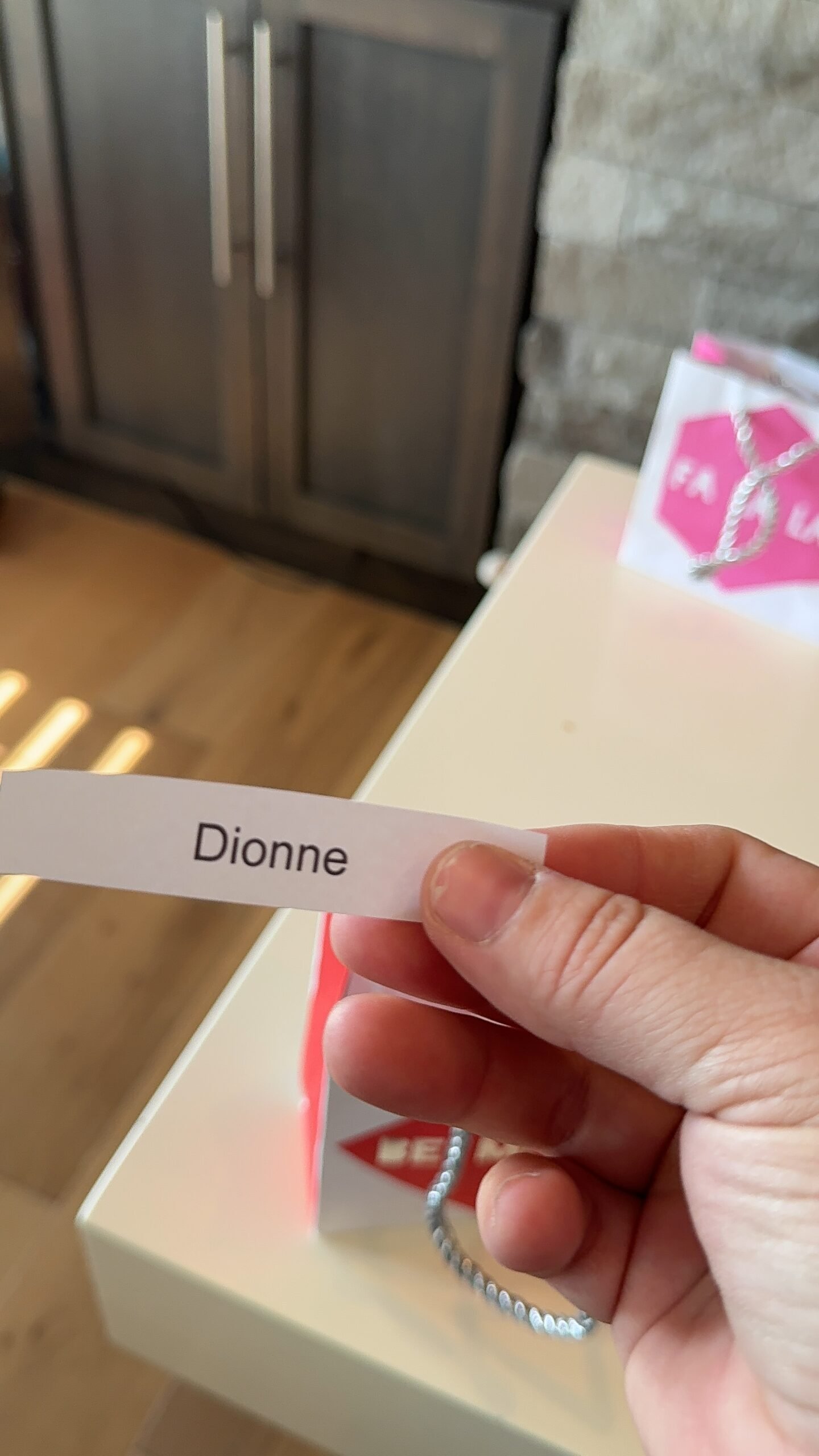 hand holding a piece of paper that says Dionne on it