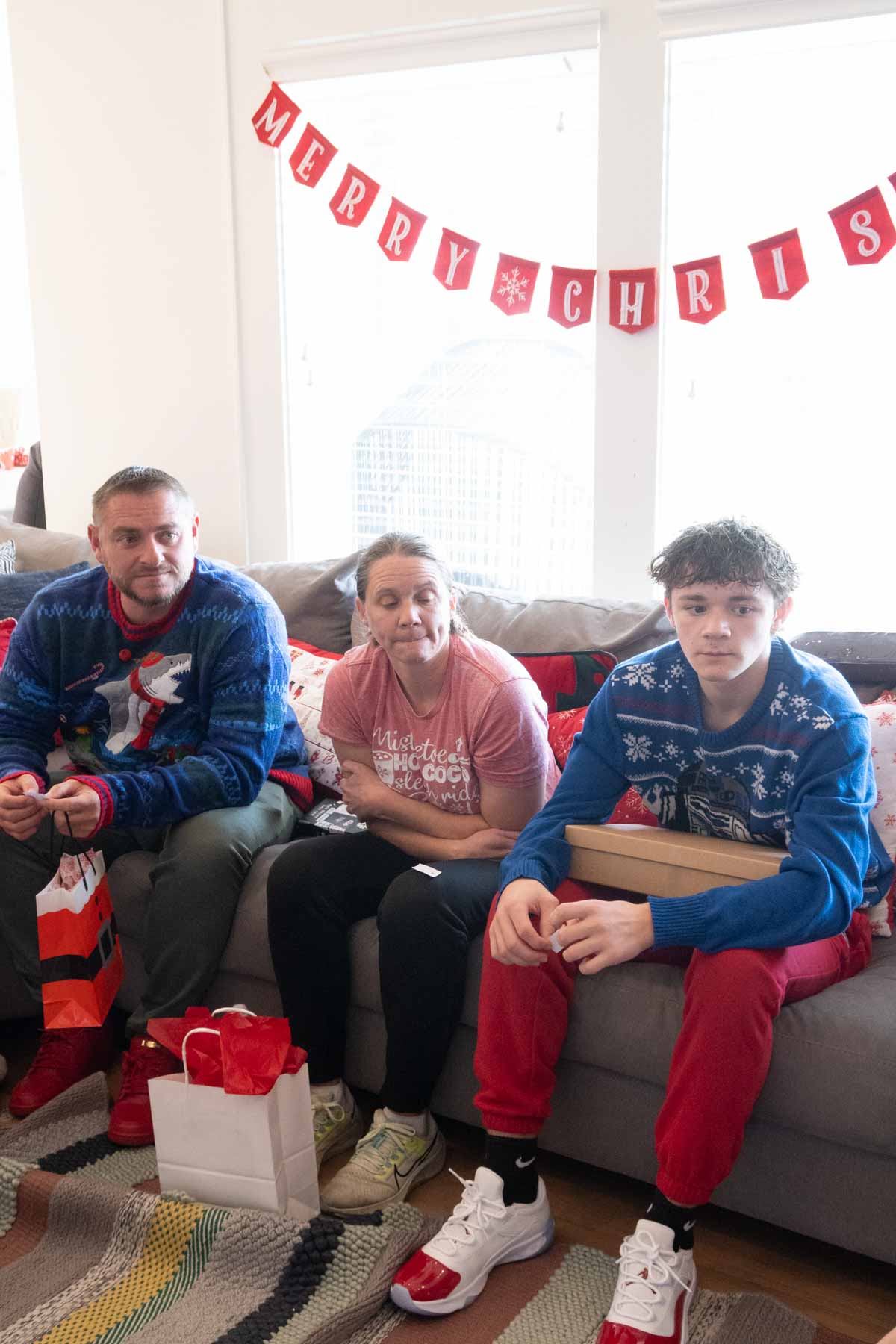 people sitting on a couch waiting to play a gift exchange game 