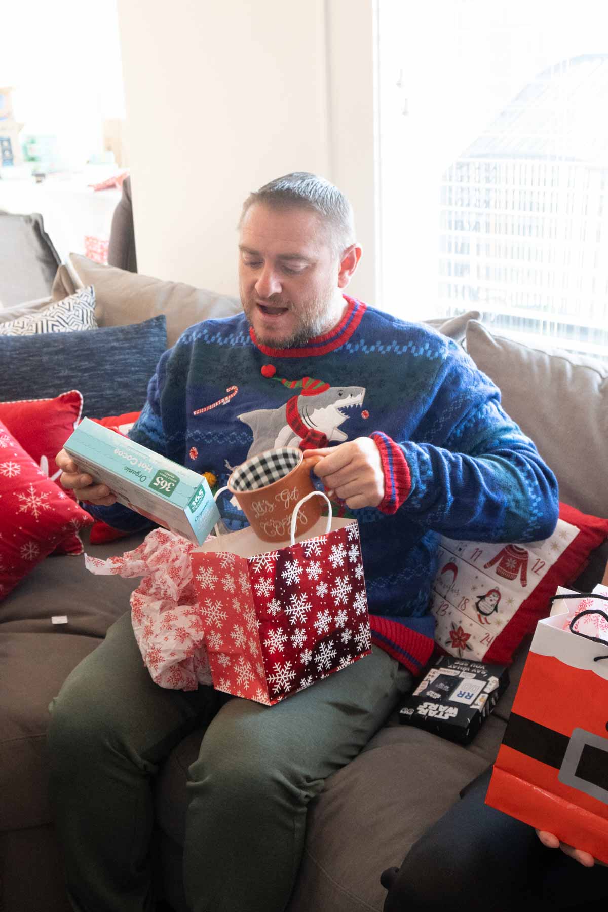 man opening a gift on a couch