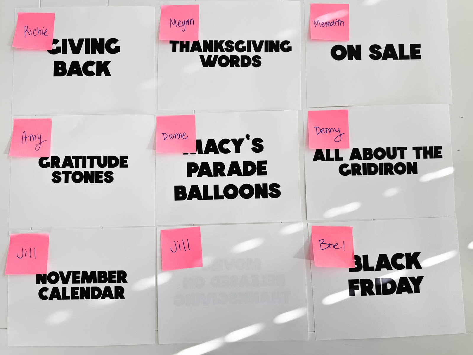 Thanksgiving categories on white pieces of paper with pink post-it notes