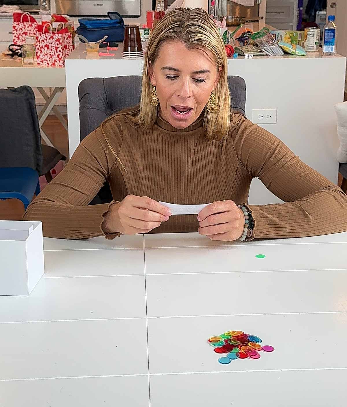 woman in a brown sweater reading a piece of paper