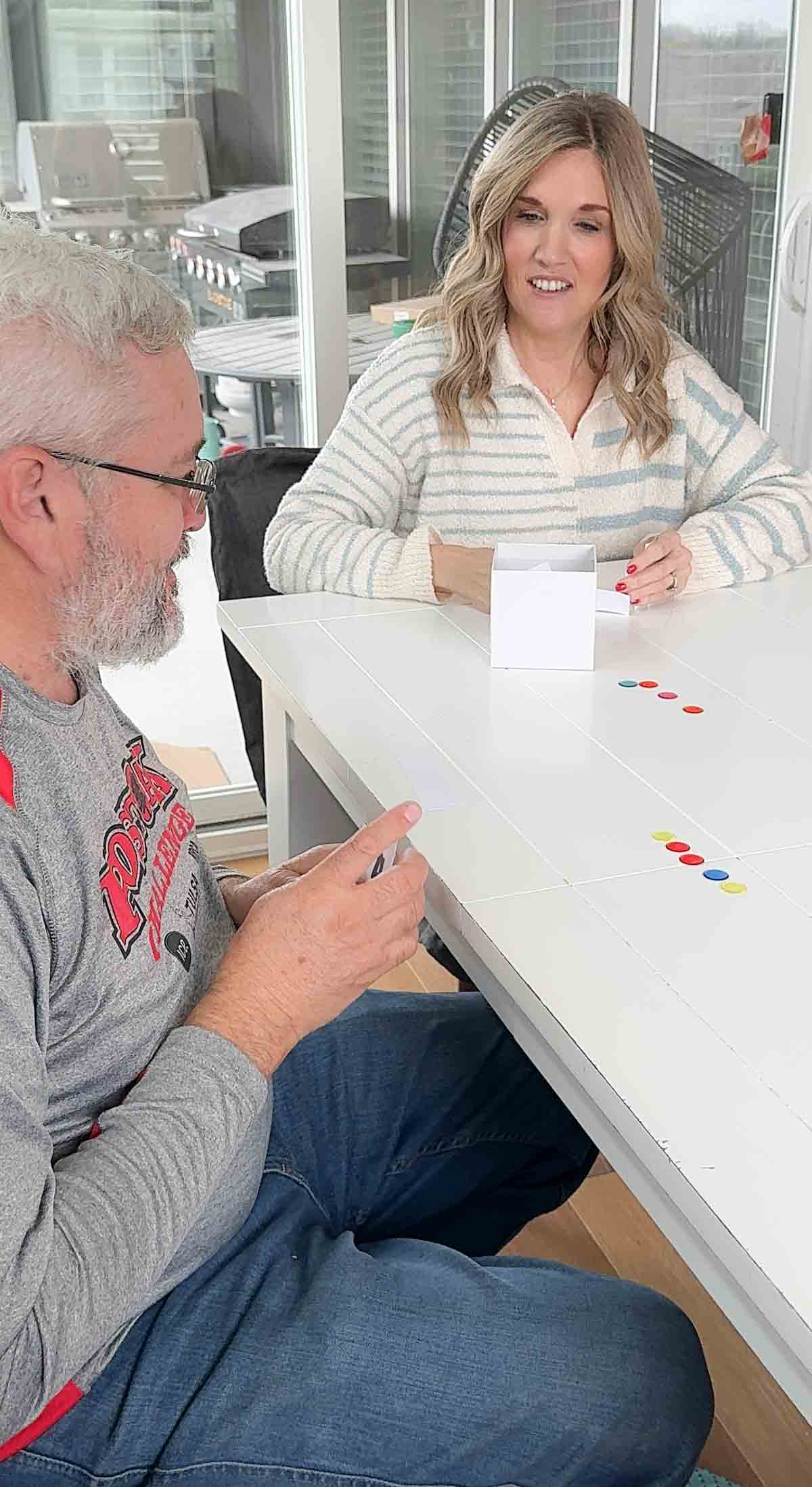 man holding numbered cards with five markers in front of him