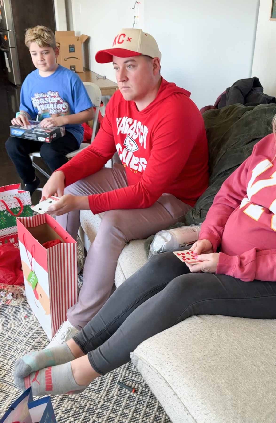 three people holding out playing cards 