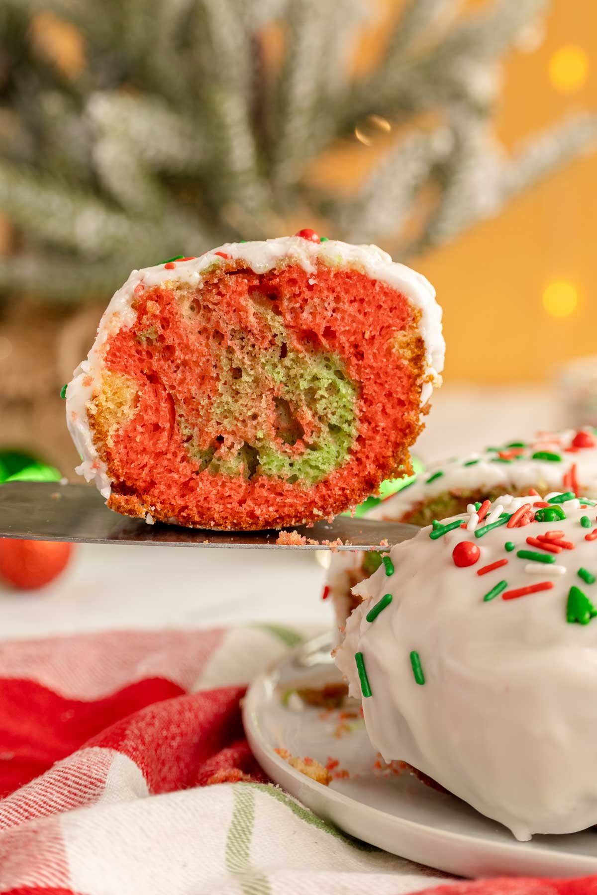 slice of Christmas bundt cake next to the rest of the cake