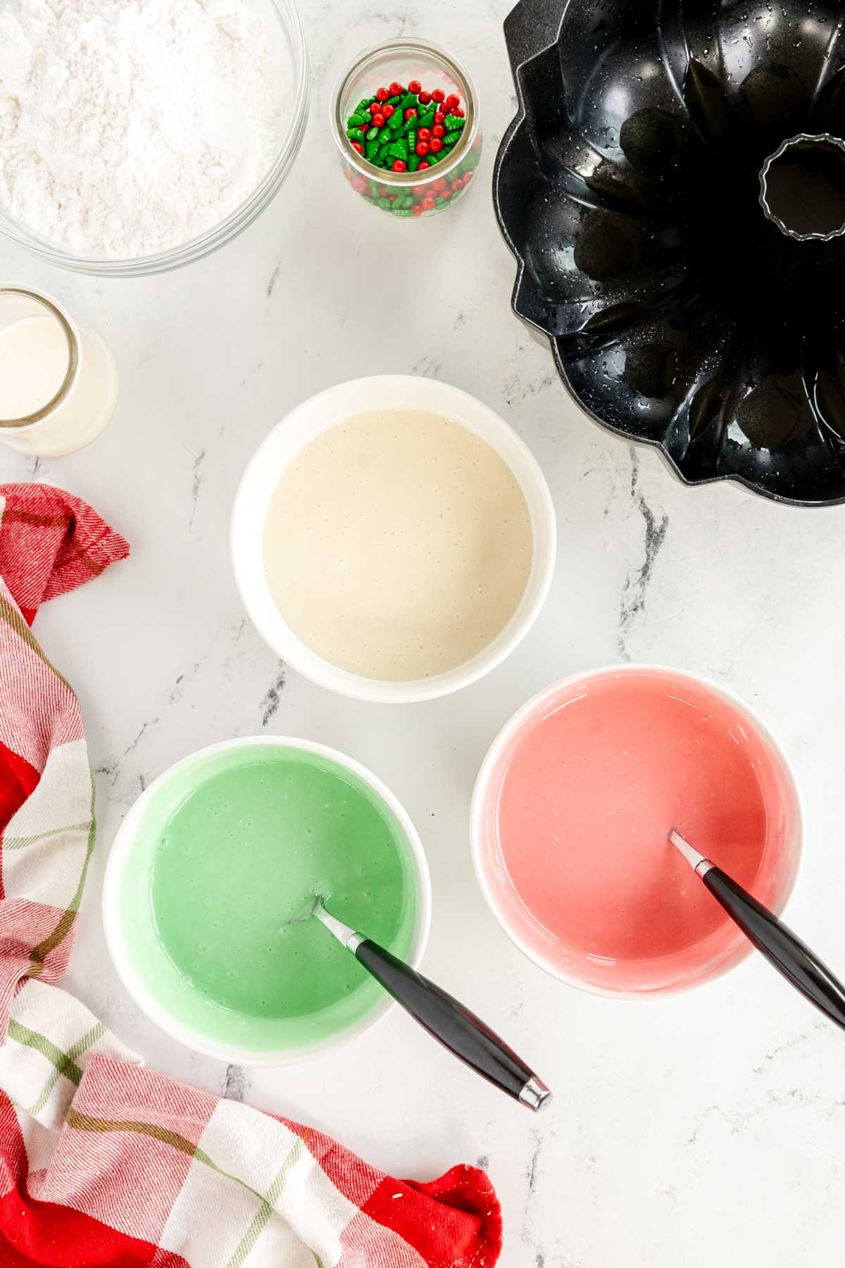 three bowls of cake batter in different colors