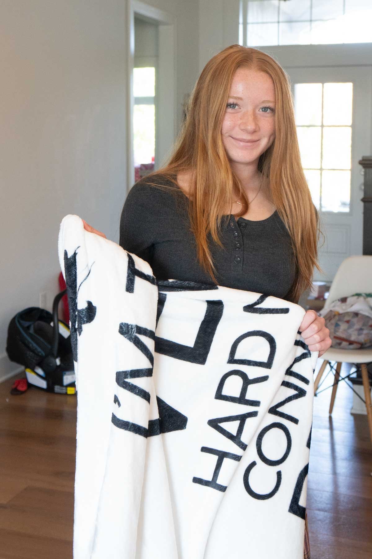 teen girl holding up a soft white blanket