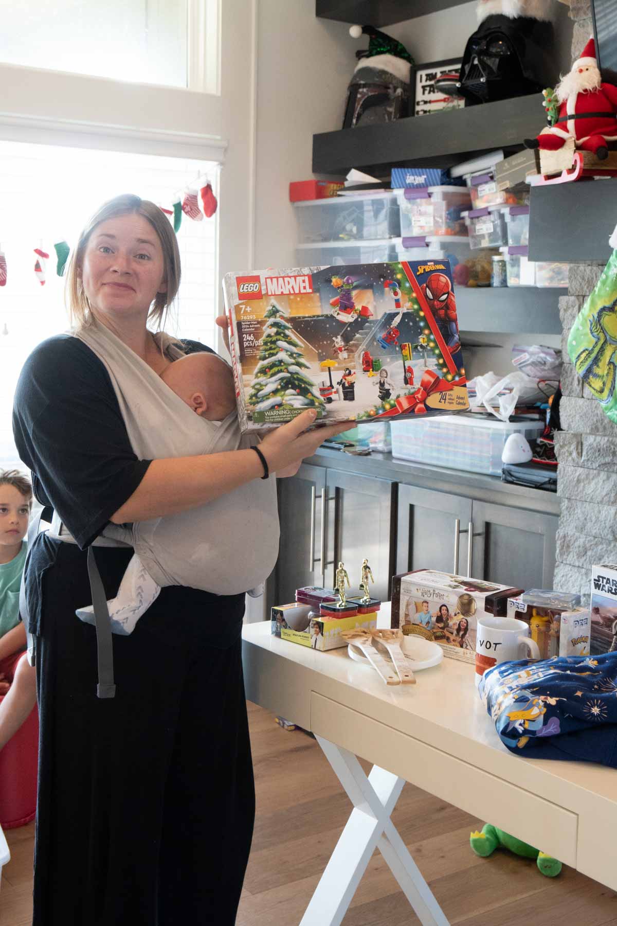 woman with a baby standing at a white table full of gifts