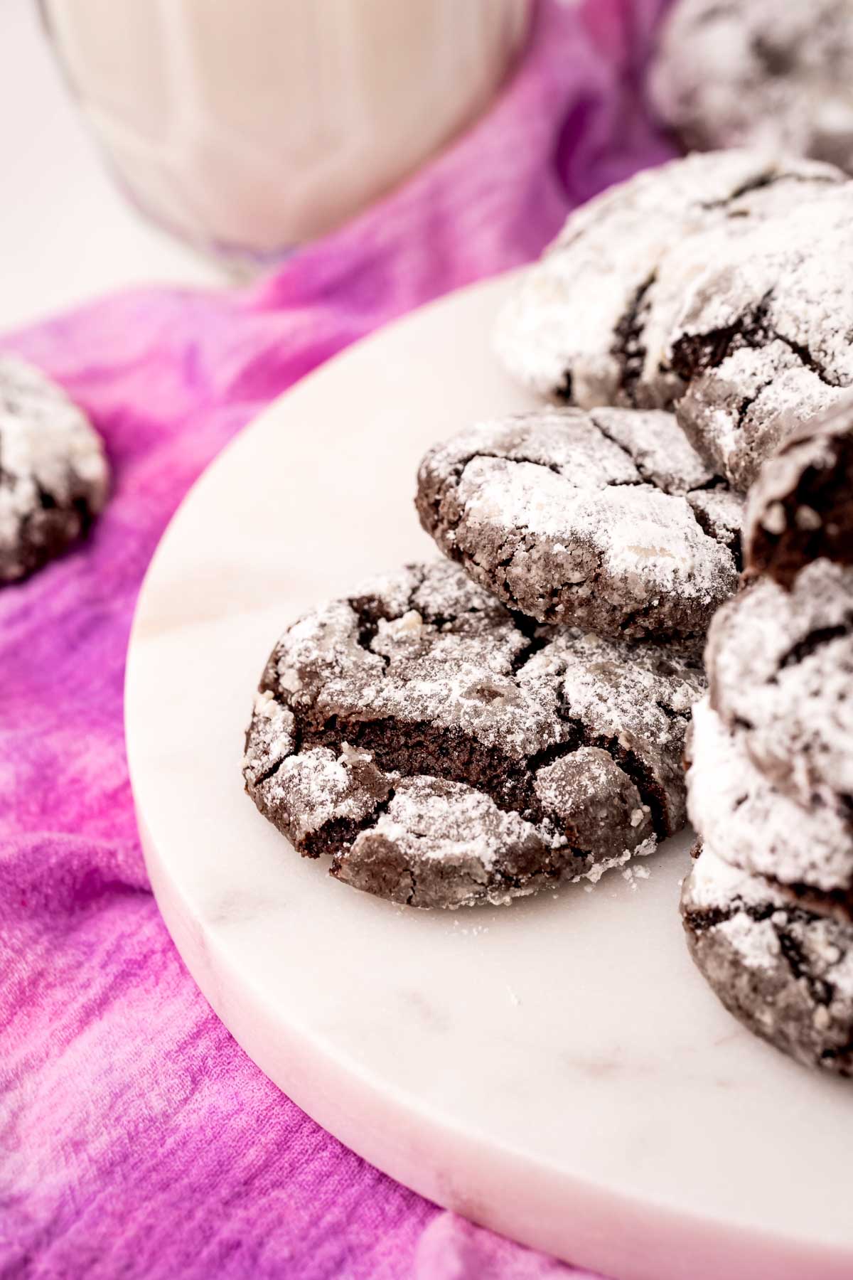 white plate with a bunch of chocolate crinkle cookies on it