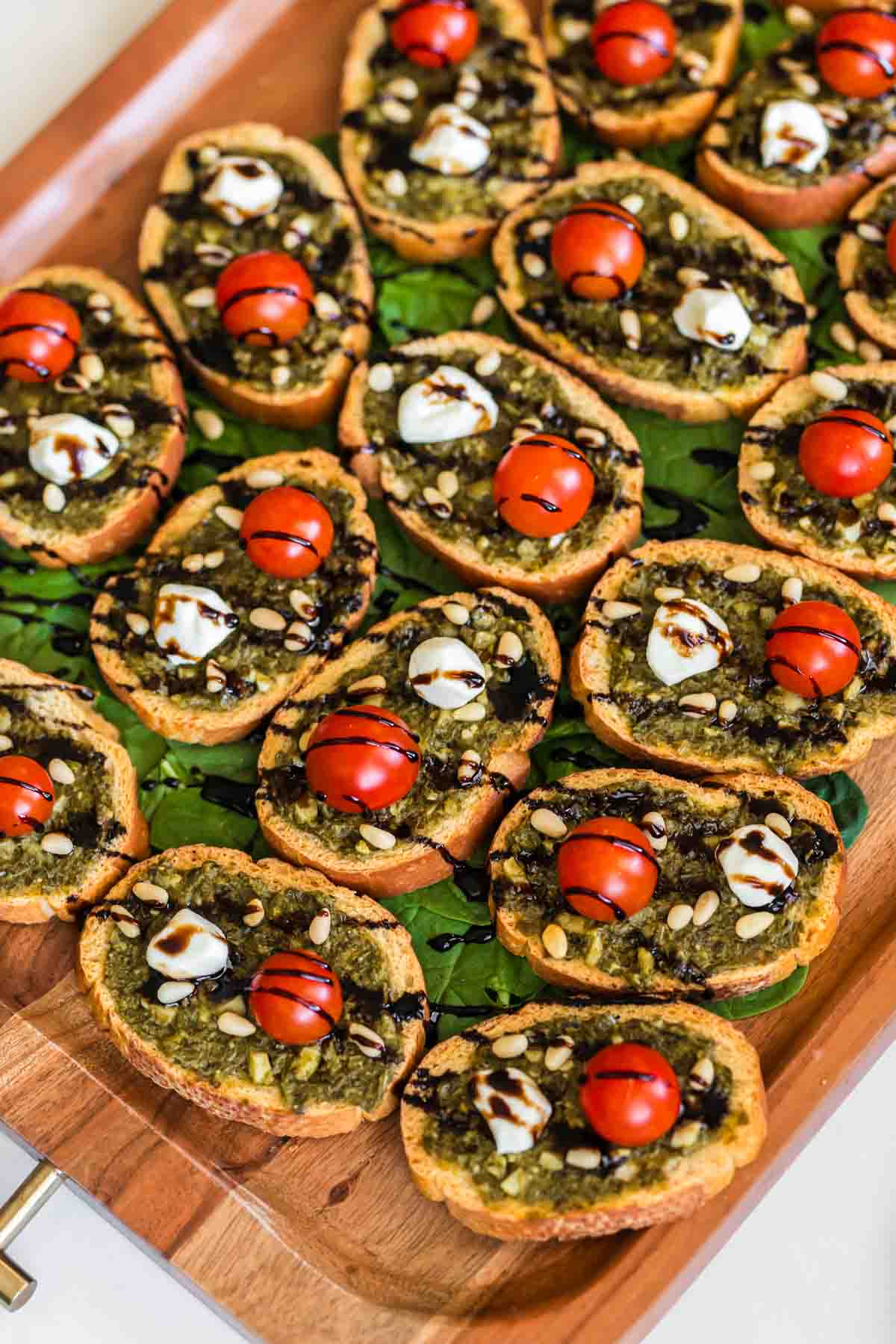 pesto crostini on a wood board