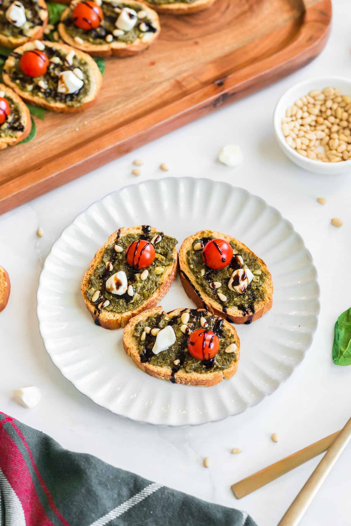 white plastic plate with pesto crostini on top