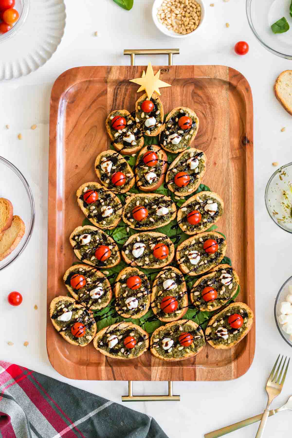 Christmas tree made with pesto crostini on a wood board