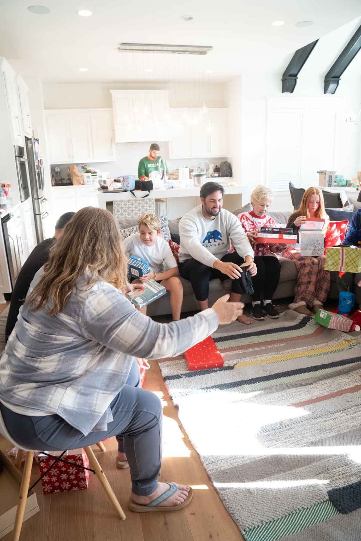 people sitting on a couch passing gifts around 