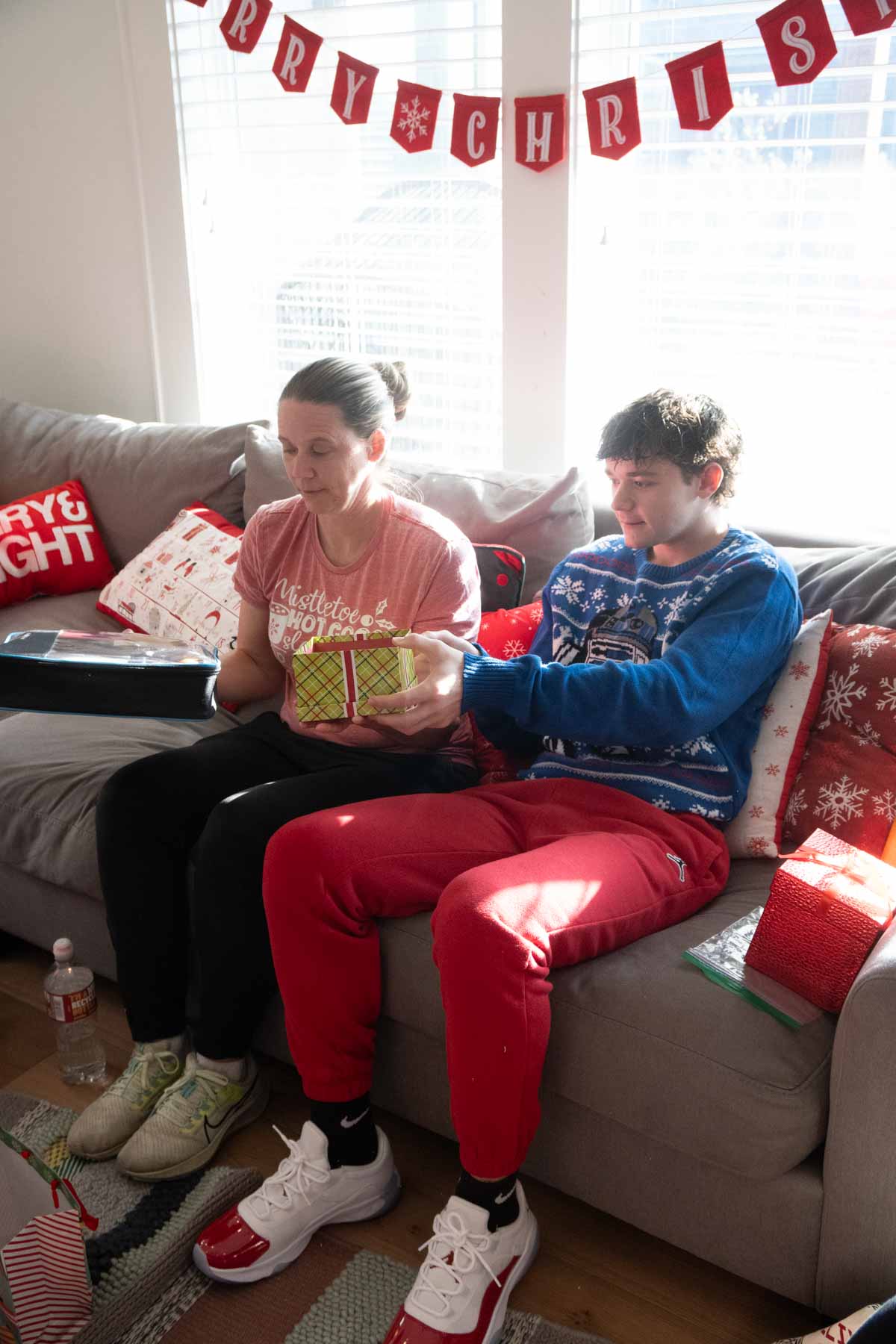 people sitting on a couch holding gifts