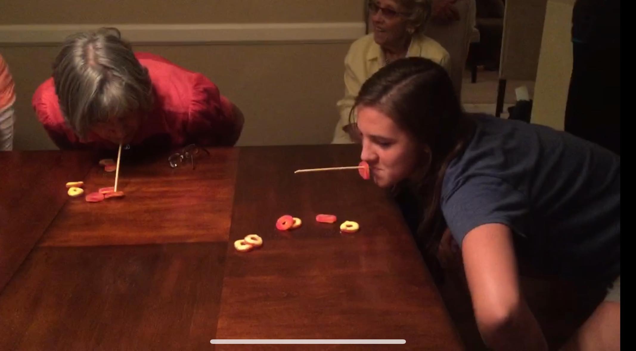 women playing a minue to win it game with candy and chopsticks