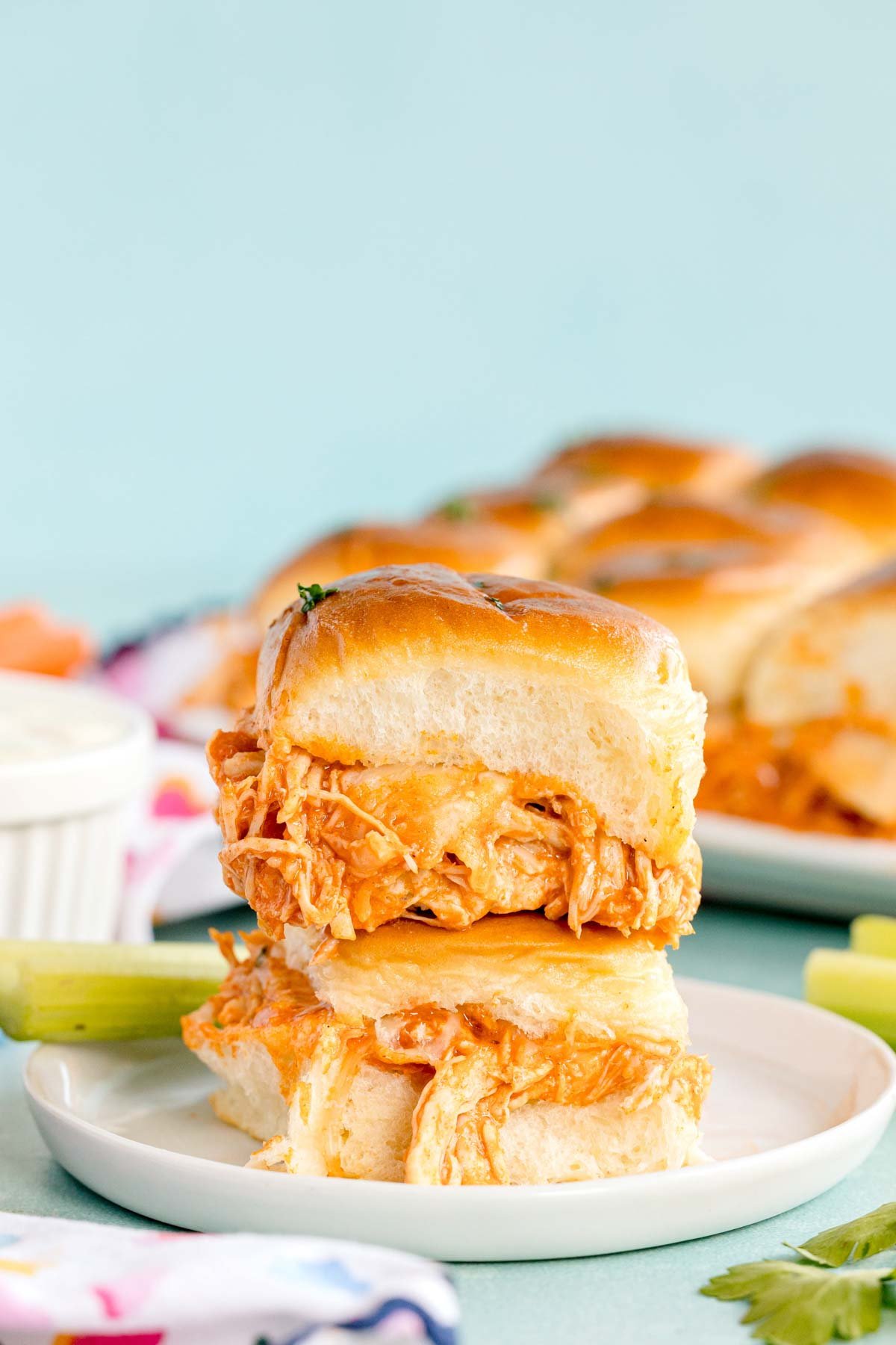 buffalo chicken sliders stacked on top of each other on a white plate