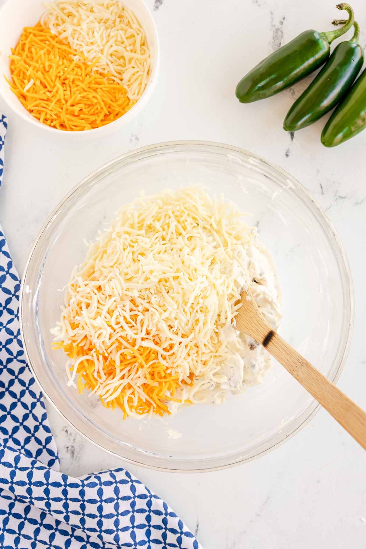 jalapeno popper dip with a spatula in a glass bowl