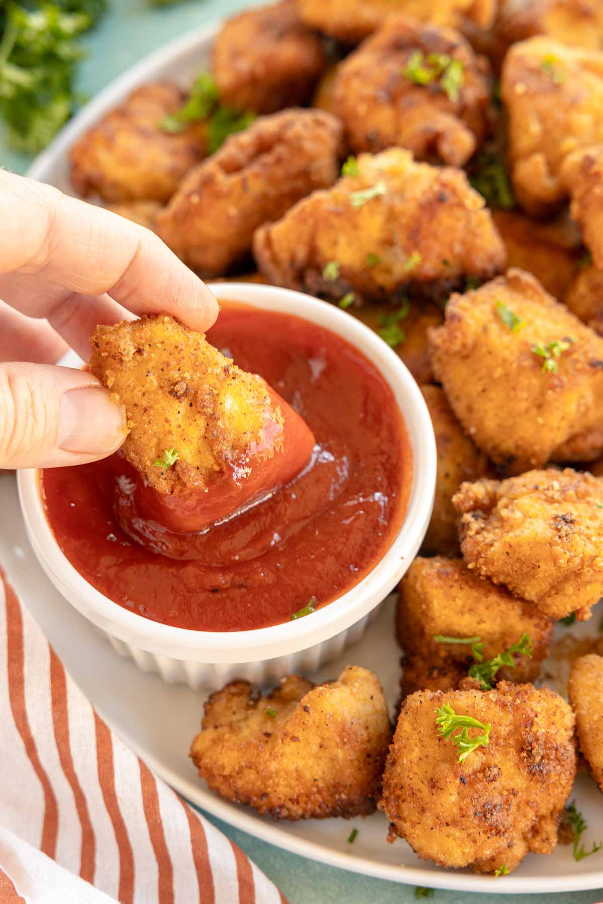 hand dipping a copycat chick-fil-a nugget in ketchup