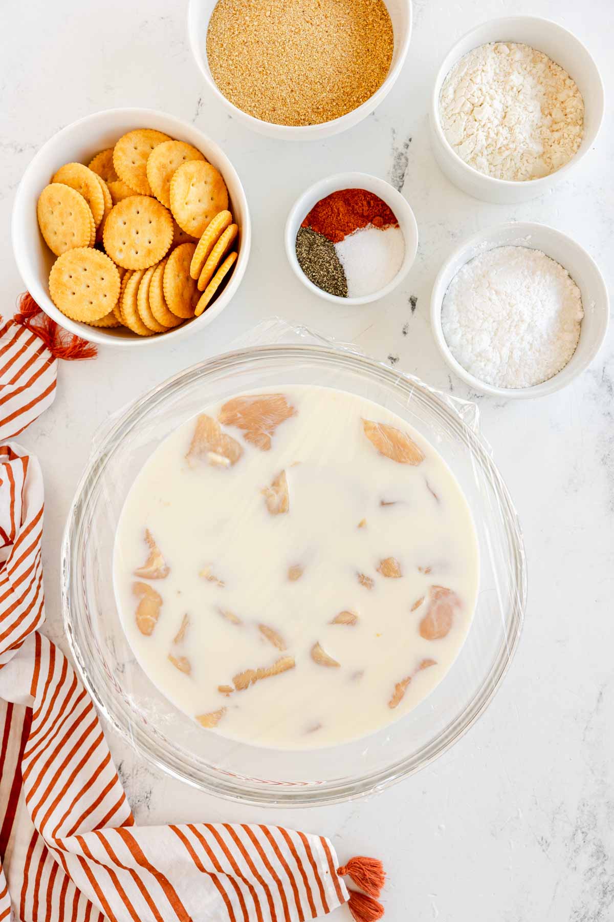 chicken pieces in a pickle juice and milk brine in a bowl