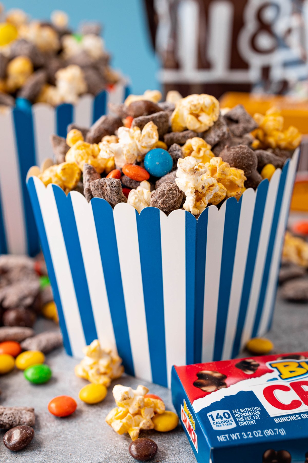 blue popcorn bucket filled with a popcorn snack mix